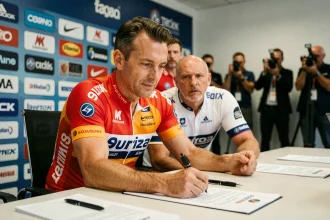 Cycliste professionnel signant son contrat de transfert lors d'une conférence de presse officielle en 2026